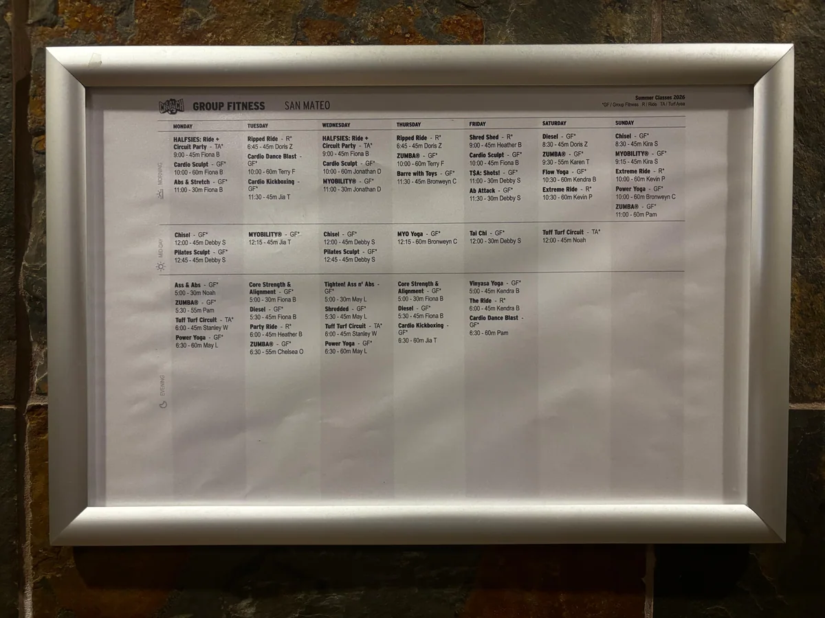 Printed Crunch San Mateo class schedule displayed on a wall